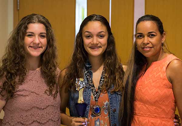 girls posing with medal in music class