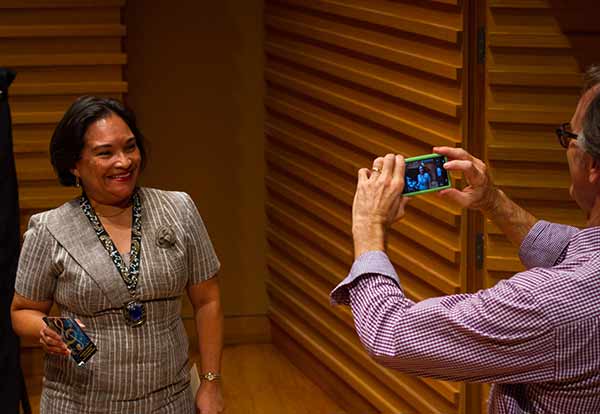 lady posing with medal in music class