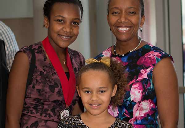 people posing with medals in music class