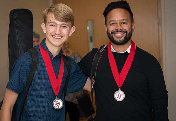 two guys posing with medals
